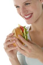 Frau hält belegtes Brötchen in der Hand